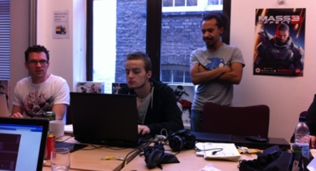 Theo Chin, Luc Shelton, and Mark Backler looking suspiciously at a computer screen in a conference room at the UKIE offices in central London.