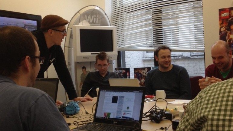 Journalists and student game developers huddled around.